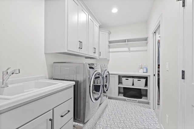 clothes washing area featuring cabinets, washer and clothes dryer, and sink