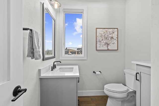 bathroom with hardwood / wood-style flooring, toilet, and vanity