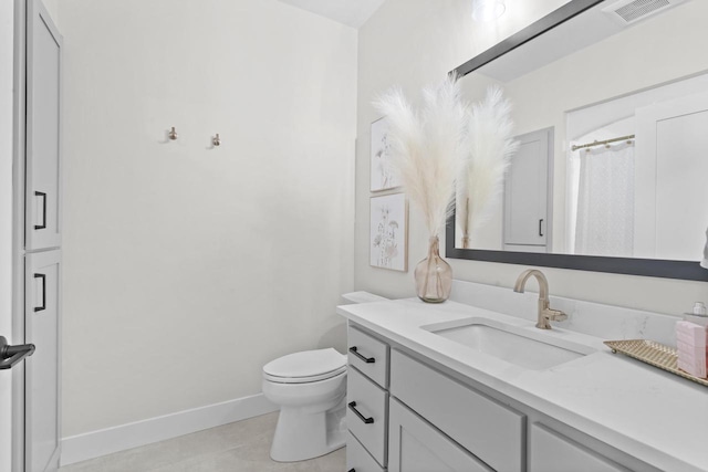 bathroom featuring toilet, tile patterned floors, and vanity