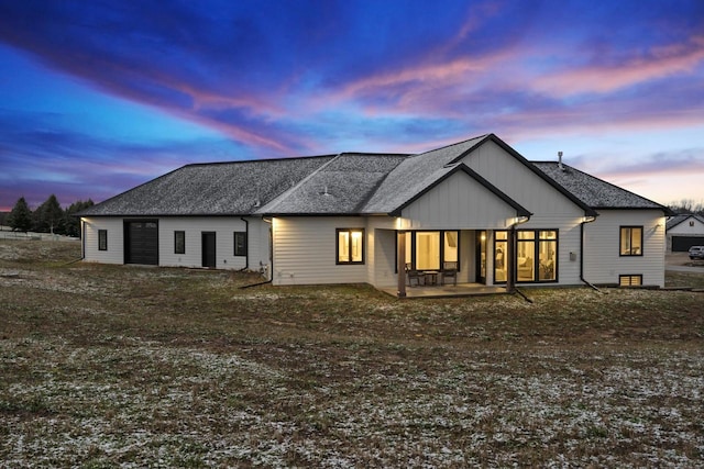 back house at dusk featuring a patio area