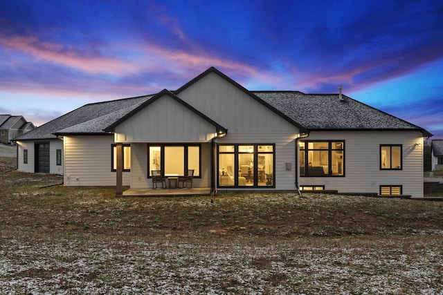 back house at dusk featuring a patio