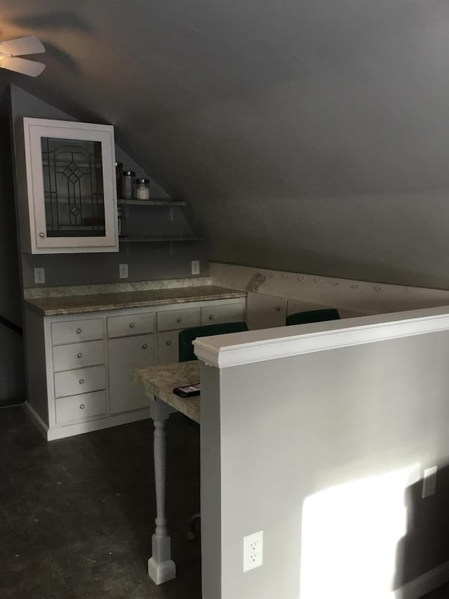 kitchen with white cabinets, a kitchen breakfast bar, lofted ceiling, and kitchen peninsula