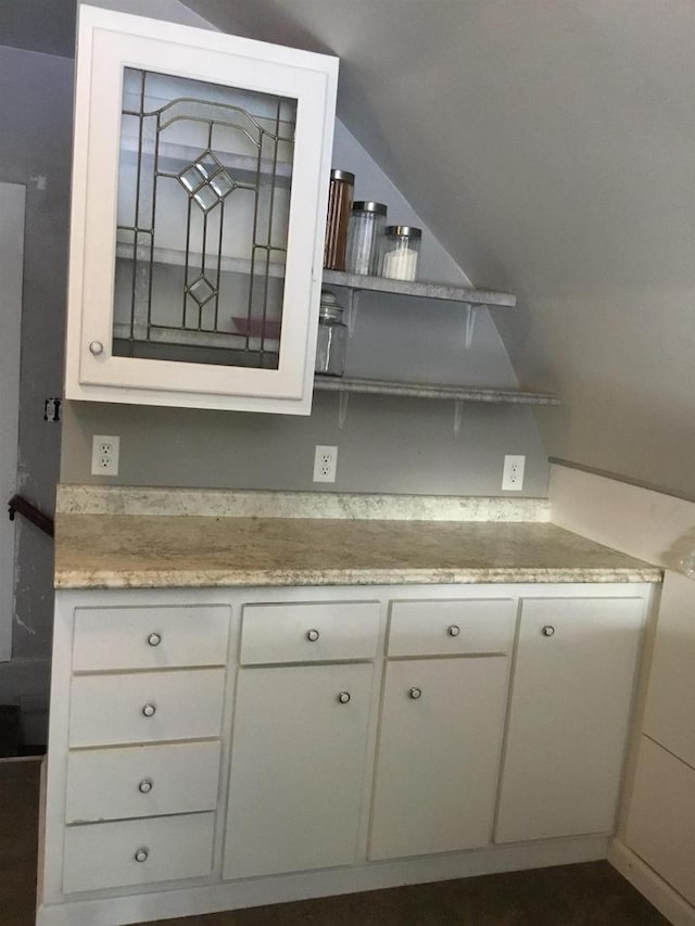 kitchen featuring white cabinetry and lofted ceiling