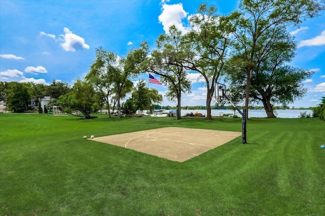 view of home's community with a lawn, a water view, and basketball court