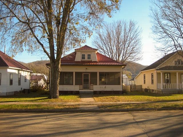 bungalow-style house with a sunroom, a front lawn, and a mountain view