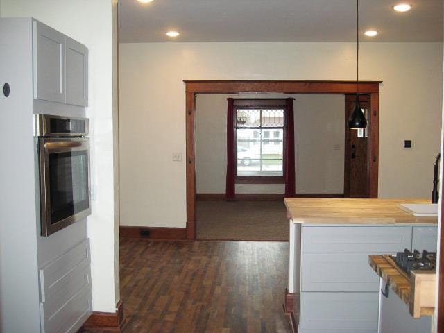 kitchen with wooden counters, oven, dark wood-type flooring, and sink