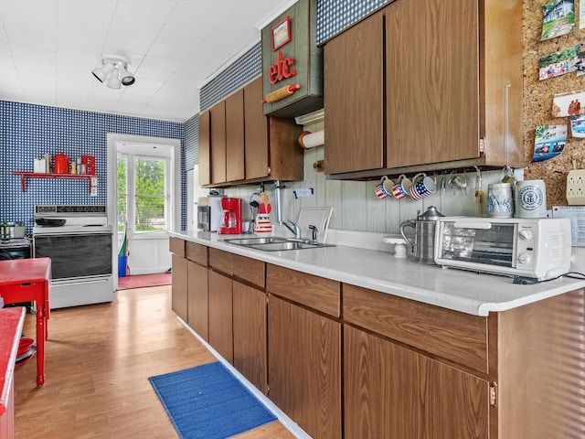W6540 County Road C, Plymouth, WI 53073 - kitchen featuring electric range oven, light countertops, light wood-style floors, wallpapered walls, and a sink