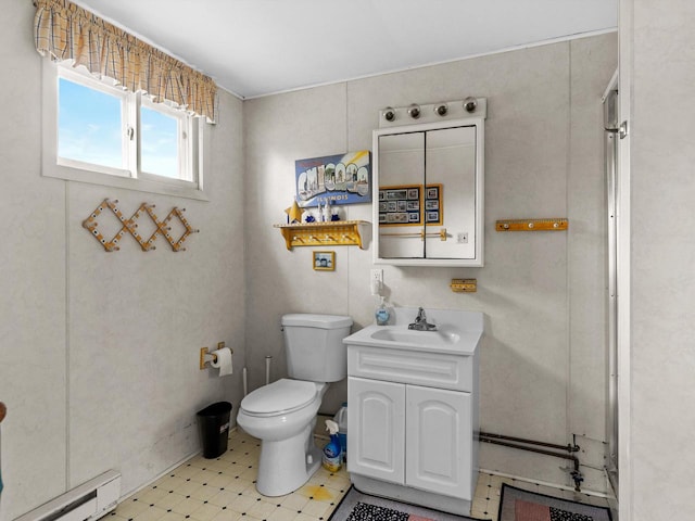 bathroom featuring toilet, vanity, and a baseboard heating unit