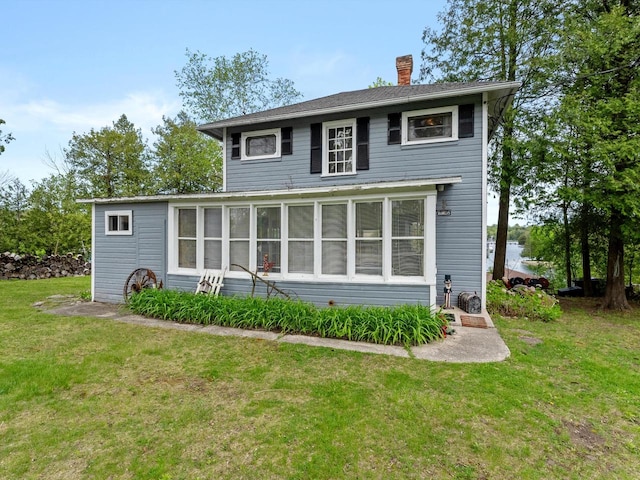 rear view of house with a yard and a sunroom