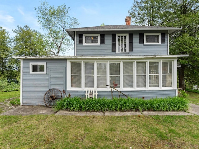 back of property featuring a sunroom and a yard