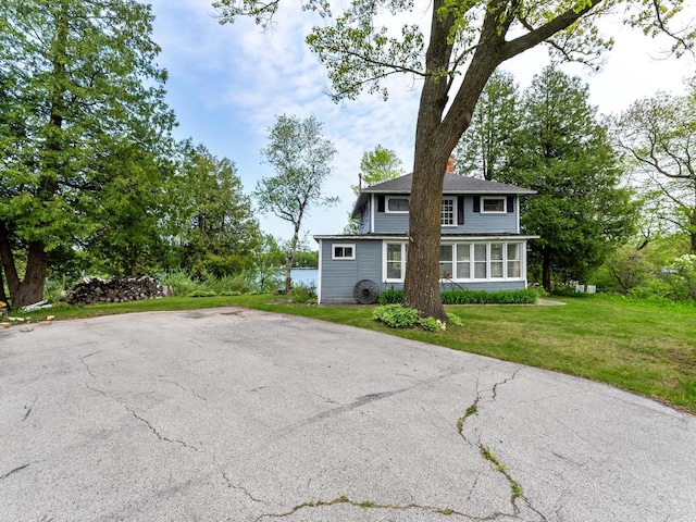 view of front of home with a front lawn and a sunroom