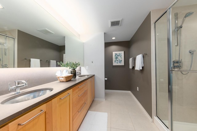 bathroom with tile patterned flooring, vanity, and a shower with shower door