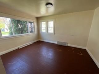 4828 N 25th St, Milwaukee, WI 53209 - unfurnished room featuring baseboards and dark wood-type flooring
