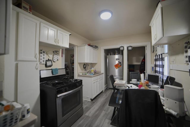 kitchen with white cabinetry, light hardwood / wood-style flooring, stainless steel appliances, and sink