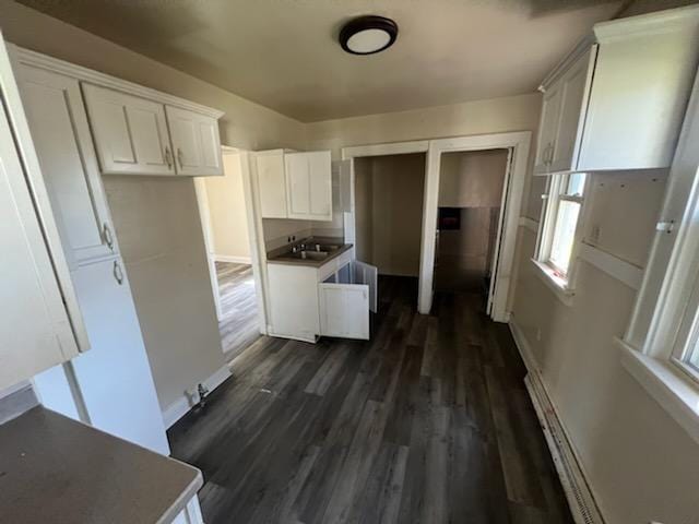 4828 N 25th St, Milwaukee, WI 53209 - kitchen with dark wood-style flooring, white cabinets, and baseboards