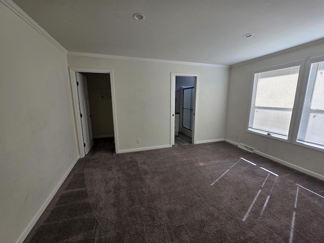 1407 N Peach Ave Unit 119, Marshfield, WI 54449 - unfurnished bedroom with crown molding, dark carpet, a spacious closet, connected bathroom, and a closet