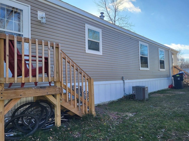 back of property featuring a lawn and central AC