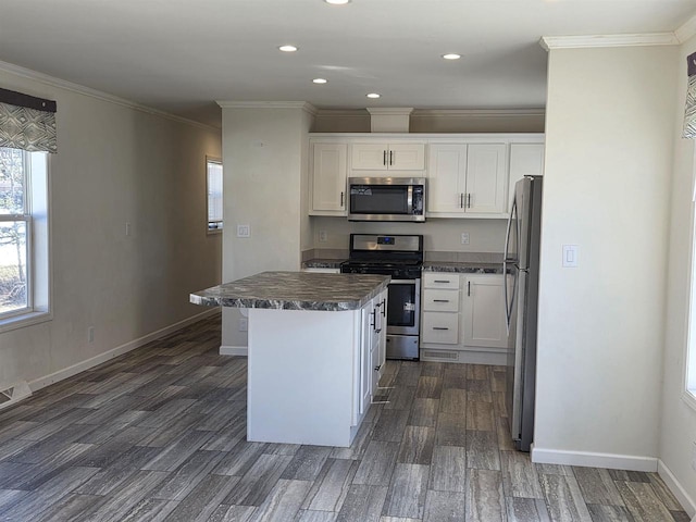 1407 N Peach Ave Unit 119, Marshfield, WI 54449 - kitchen featuring appliances with stainless steel finishes, dark countertops, dark wood-type flooring, white cabinets, and a kitchen island