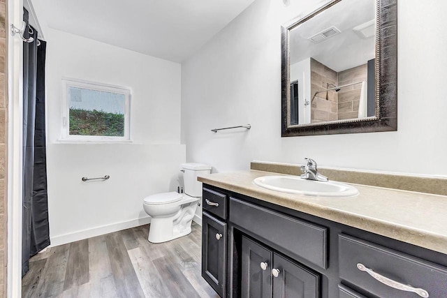 bathroom with vanity, wood-type flooring, toilet, and walk in shower