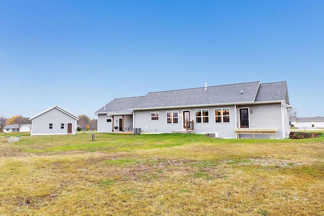 rear view of house featuring a yard and central AC