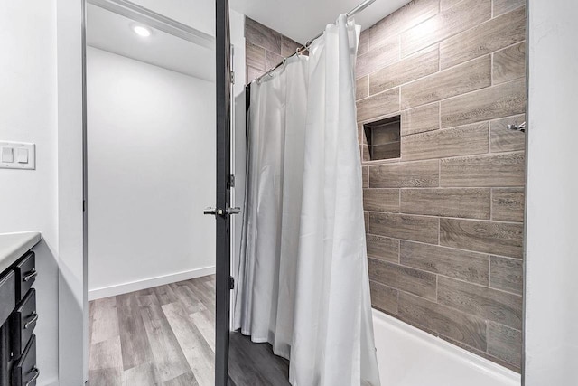 bathroom featuring hardwood / wood-style flooring, vanity, and shower / bath combination with curtain