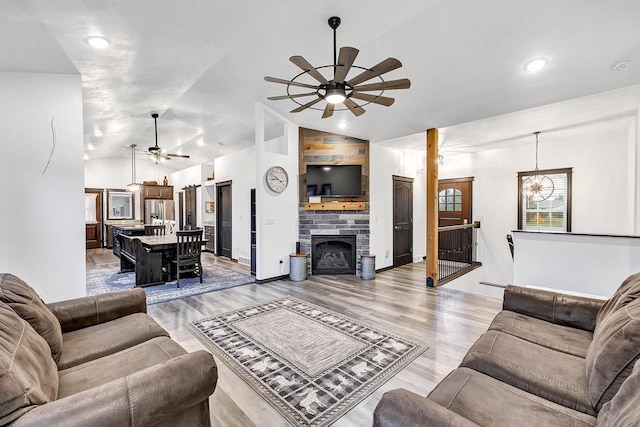 living room featuring ceiling fan, lofted ceiling, and light hardwood / wood-style floors