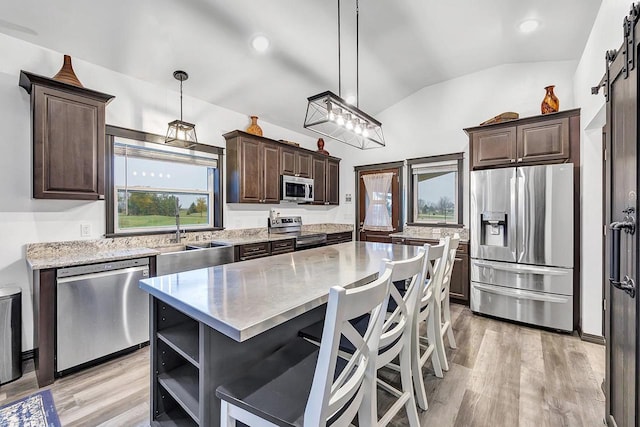 kitchen with pendant lighting, sink, a center island, and appliances with stainless steel finishes