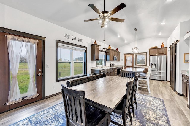 dining space featuring ceiling fan, vaulted ceiling, and light hardwood / wood-style flooring