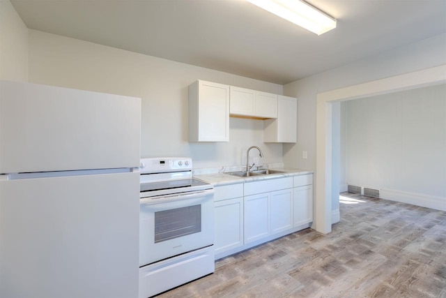 kitchen with light wood-type flooring, white appliances, white cabinetry, and sink