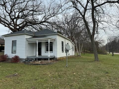 exterior space with covered porch and a yard