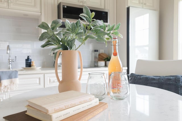 details featuring backsplash and cream cabinets