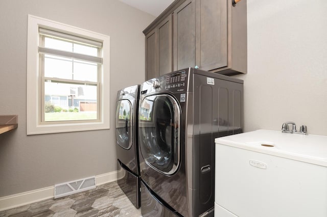 clothes washing area featuring cabinets and independent washer and dryer