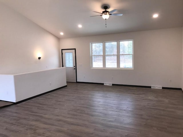 empty room with ceiling fan, dark hardwood / wood-style flooring, and vaulted ceiling