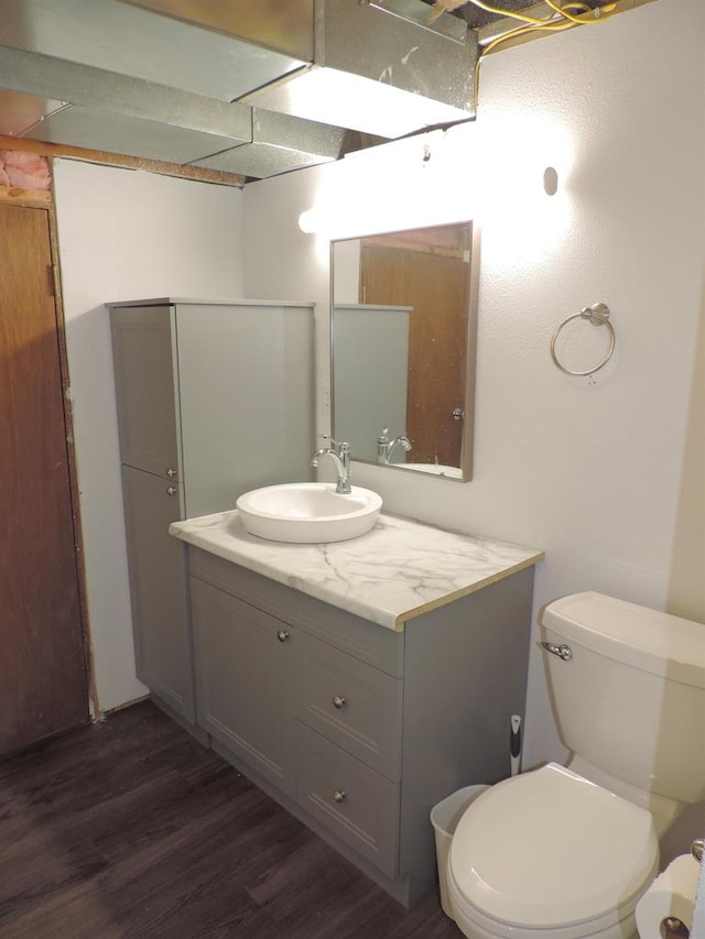 bathroom with wood-type flooring, vanity, and toilet