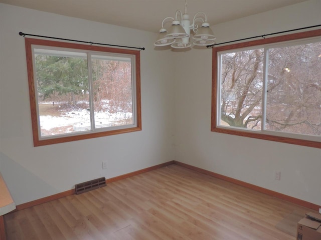 unfurnished dining area featuring light hardwood / wood-style flooring and a notable chandelier