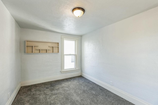 carpeted spare room featuring a textured ceiling