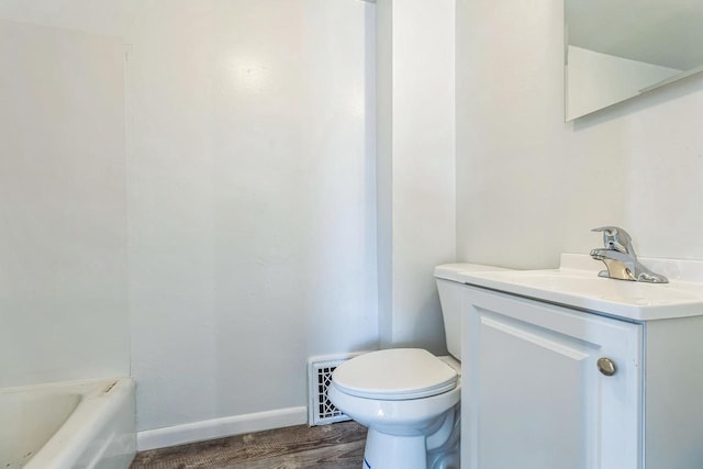 bathroom featuring a bathing tub, vanity, toilet, and hardwood / wood-style floors