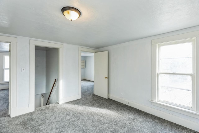 carpeted empty room featuring a textured ceiling