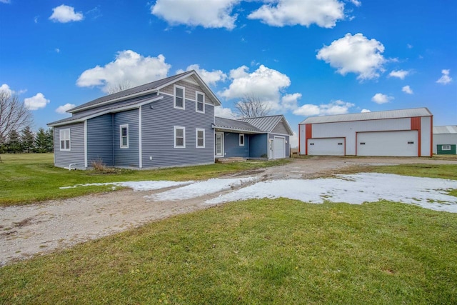 view of front of home with a garage, an outbuilding, and a front yard