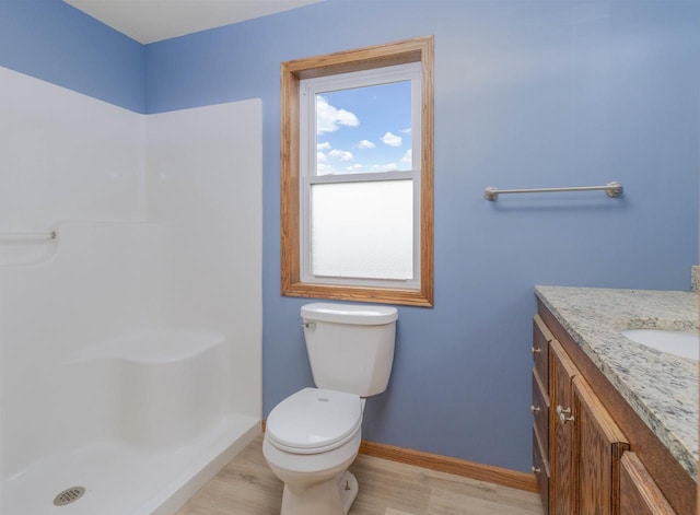 bathroom with a shower, hardwood / wood-style floors, vanity, and toilet