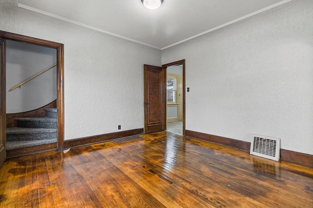 empty room with crown molding and dark wood-type flooring