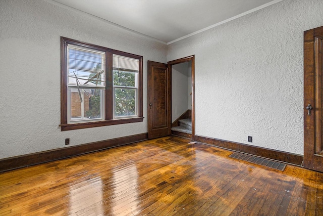 unfurnished room with dark hardwood / wood-style flooring and ornamental molding