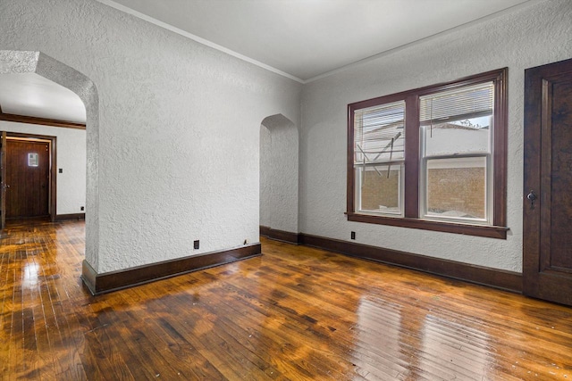 unfurnished room with crown molding and dark wood-type flooring