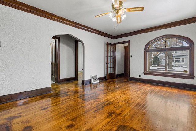 spare room with crown molding, ceiling fan, and dark wood-type flooring