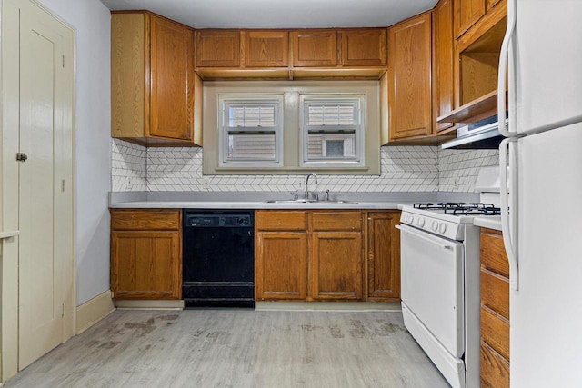 kitchen featuring white appliances, backsplash, light hardwood / wood-style floors, and sink