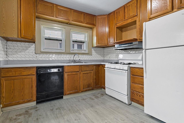 kitchen with sink, tasteful backsplash, light hardwood / wood-style flooring, white appliances, and exhaust hood