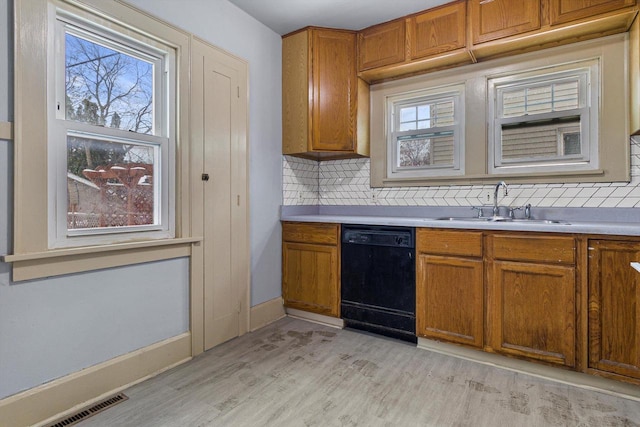 kitchen with black dishwasher, tasteful backsplash, light hardwood / wood-style flooring, and sink