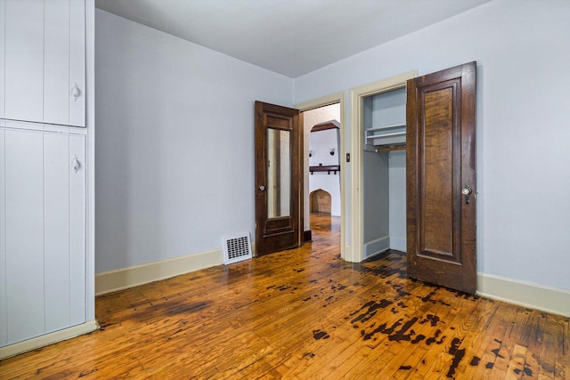 unfurnished bedroom featuring dark hardwood / wood-style floors and a closet