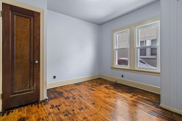 empty room with dark hardwood / wood-style flooring