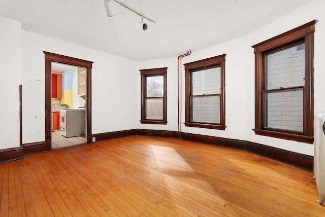 unfurnished room featuring rail lighting and light hardwood / wood-style flooring